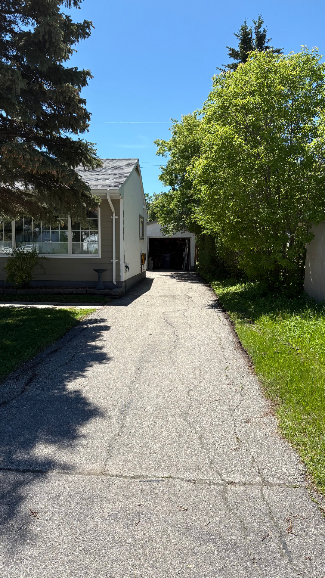 Faded, cracked asphalt driveway before sealcoating